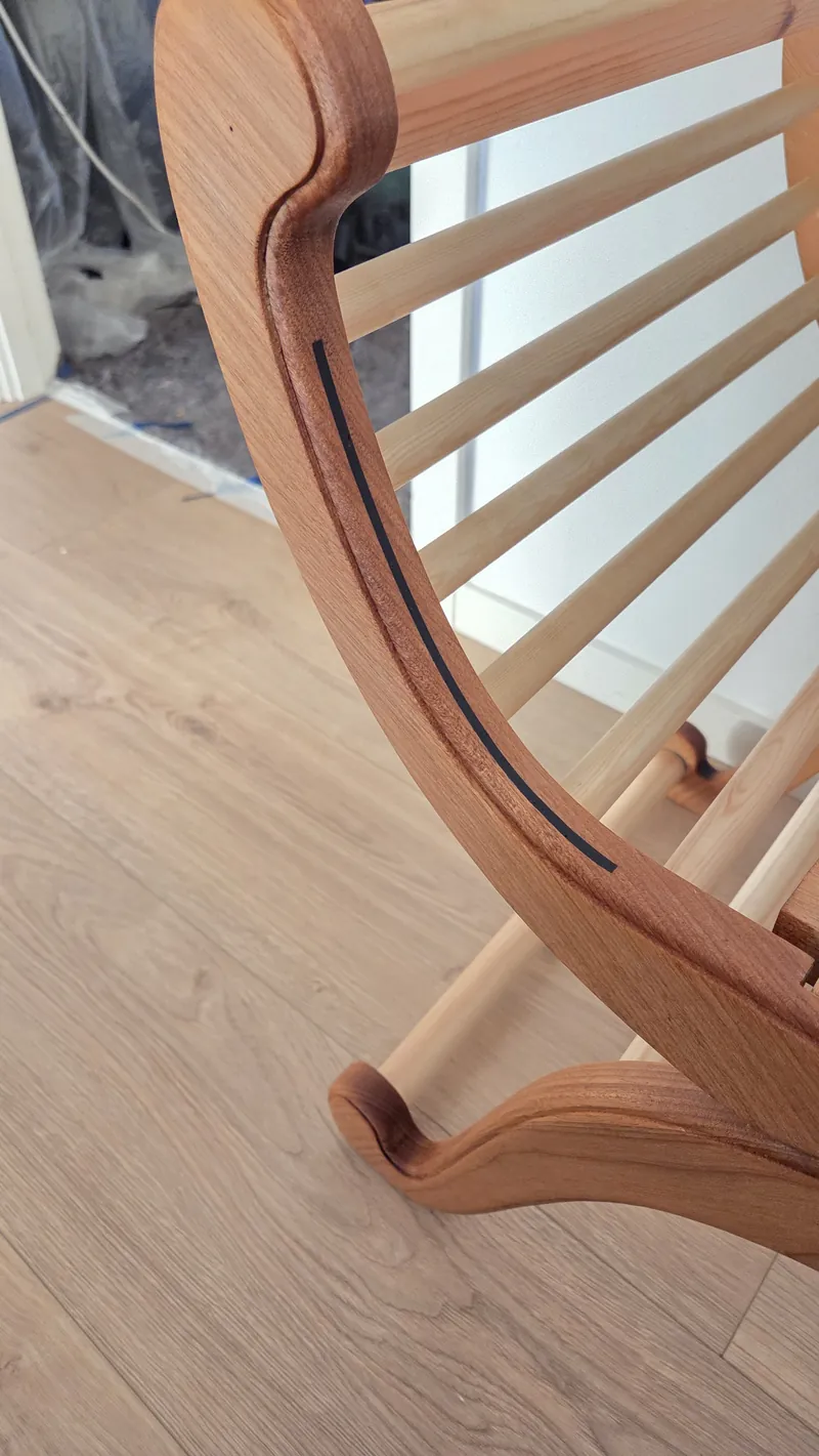 Close-up photo of the curved armrest joining the seat slats