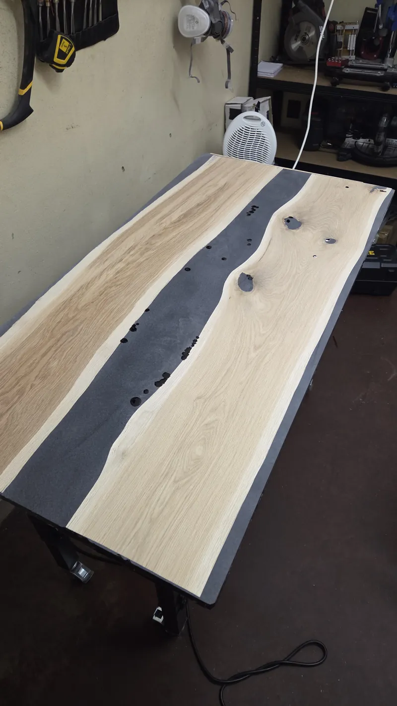 The top after casting, with a dark resin river between the oak slabs