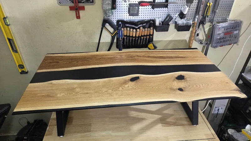 Photo of the finished oak and black resin table top on steel legs in the workshop